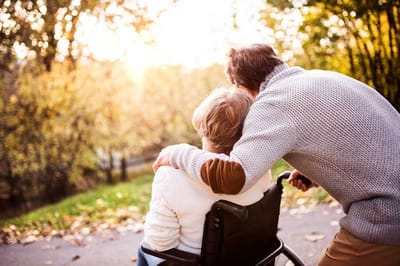 A caregiver and a resident enjoying a walk in an outdoor area