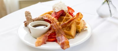Plate of waffles with fruit and syrup