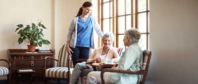 Care staff interacting with residents in a cozy lounge area
