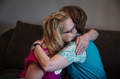 Two residents hugging in a cozy living room