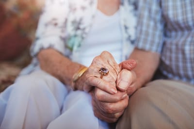 Close-up of two residents holding hands