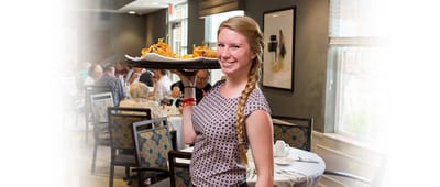 Staff member serving food in dining area