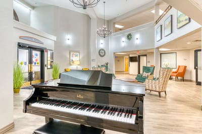 Bright lobby area with a piano and seating