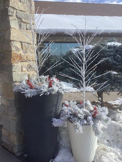 Decorative planters with snowy decor outside the facility