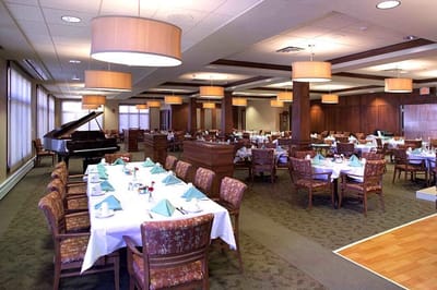 Dining room setup with tables and piano