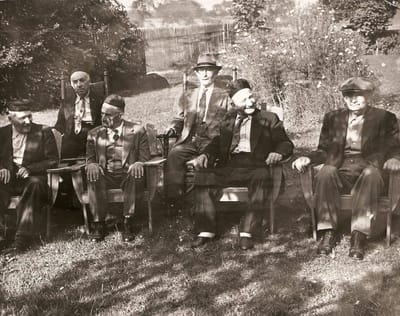 Group of men sitting in chairs outdoors