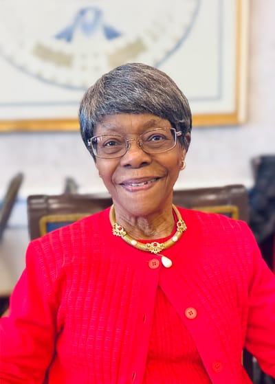 Smiling resident wearing a red sweater in a bright interior