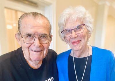 Two residents smiling together in a common area