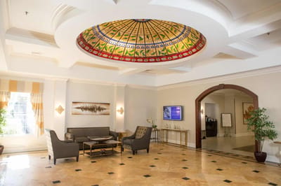 Bright lobby area with decorative ceiling and seating