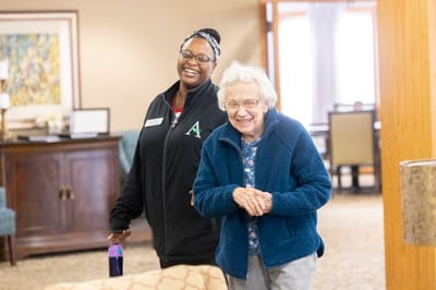 Staff member and resident smiling in a common area