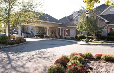 Exterior view of CareOne at Lowell entrance with landscaping