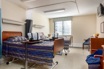 Private resident room with two beds and personal items
