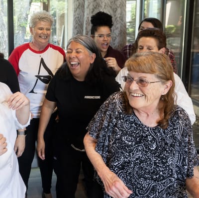 Staff and residents sharing a joyful moment indoors