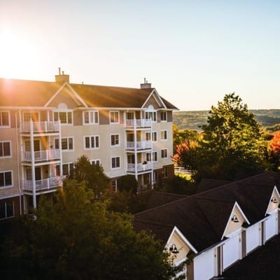 Exterior view of Benchmark Senior Living facility with sunset
