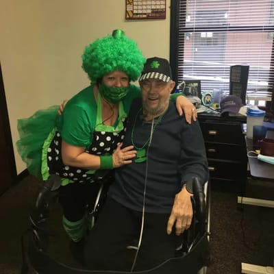 A staff member in costume with a resident celebrating St. Patrick's Day