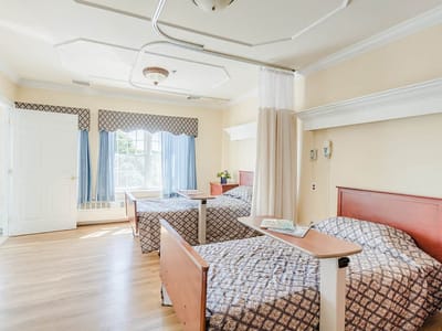 Shared resident room with two beds and natural lighting