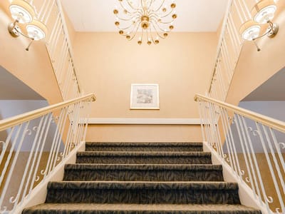Interior staircase with chandelier and wall decor