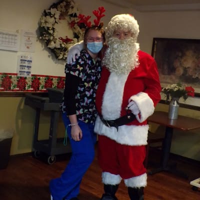 Staff member in festive attire with Santa