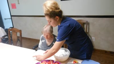 Staff assisting a resident in a dining area