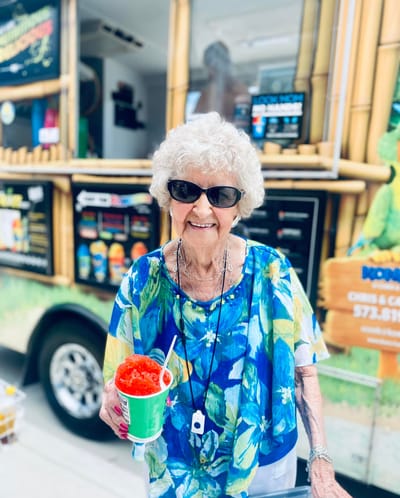 Senior woman enjoying a snow cone outside a food truck