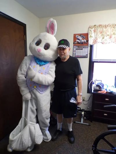 Resident posing with an Easter Bunny mascot in a common area