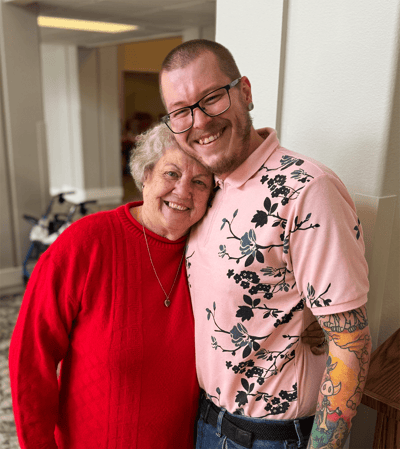 Resident and staff member smiling together in a common area