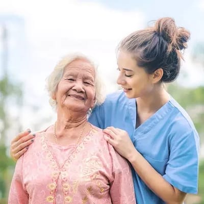 Nurse helping a senior resident outdoors