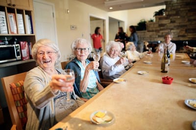 Residents celebrating with drinks at a communal table