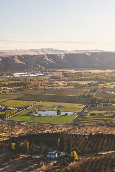 Aerial view of a rural landscape with fields and a pond