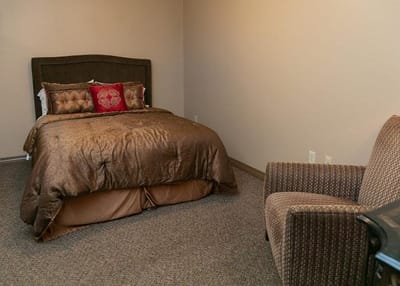 Cozy private resident room with a bed and chair