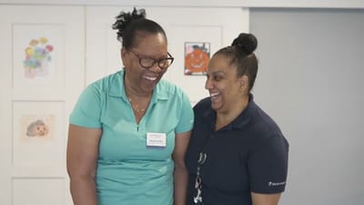 Two staff members smiling together