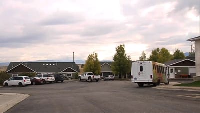 Parking lot with facility transport vehicles and buildings in view