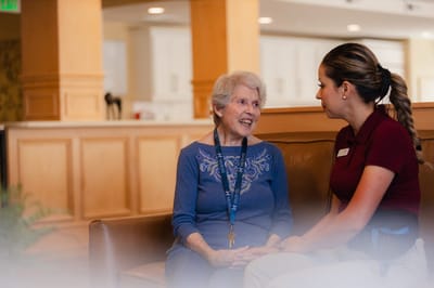 A resident conversing with staff in the lobby