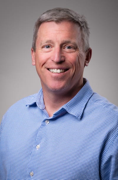 Smiling man in a blue checkered shirt