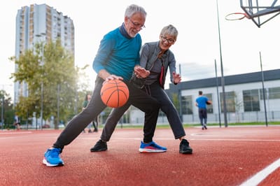 Senior residents playing basketball on an outdoor court