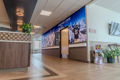 Interior hallway with decorative murals and reception area