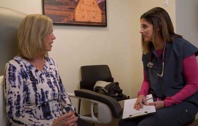 A caregiver interacting with a resident in a well-lit room