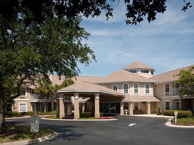 Front entrance of a senior living facility with landscaped surroundings