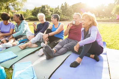 Seniors enjoying yoga outdoors on mats