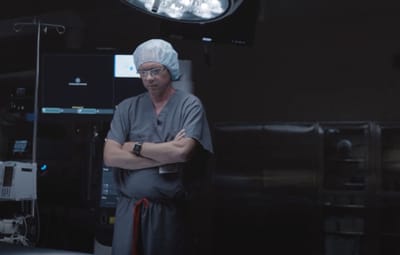 A healthcare professional in a dimly lit operating room