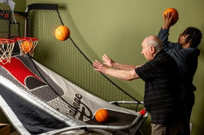 Residents enjoying a basketball shooting game indoors