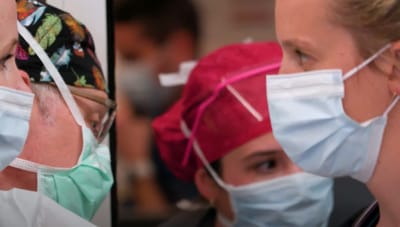Healthcare workers in masks and scrubs in a facility