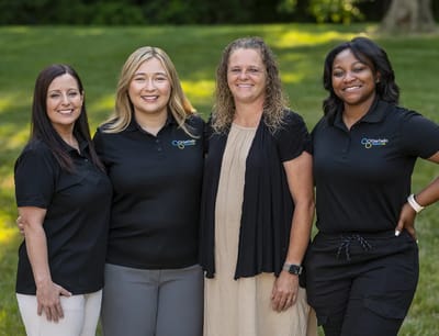 Staff posing outside in green space