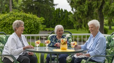 Three women enjoying drinks on an outdoor patio