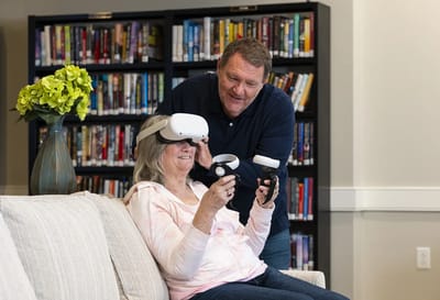 Resident using virtual reality headset with staff assistance