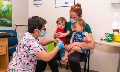 Healthcare professional administering a vaccine to children