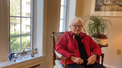 A resident sitting in a cozy chair by the window