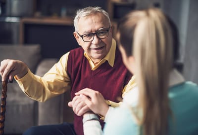 Senior resident talking with caregiver in a cozy setting