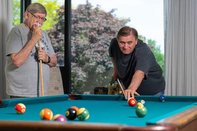 Residents playing pool in a common area