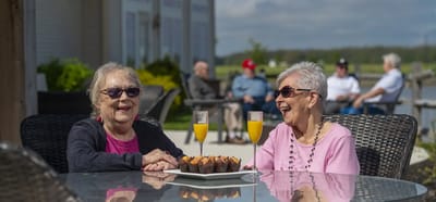 Two residents enjoying drinks and cupcakes outdoors